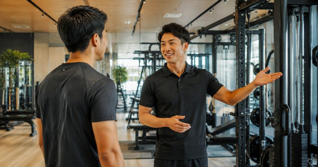 ジムのスタッフが見学者に施設を案内している様子
