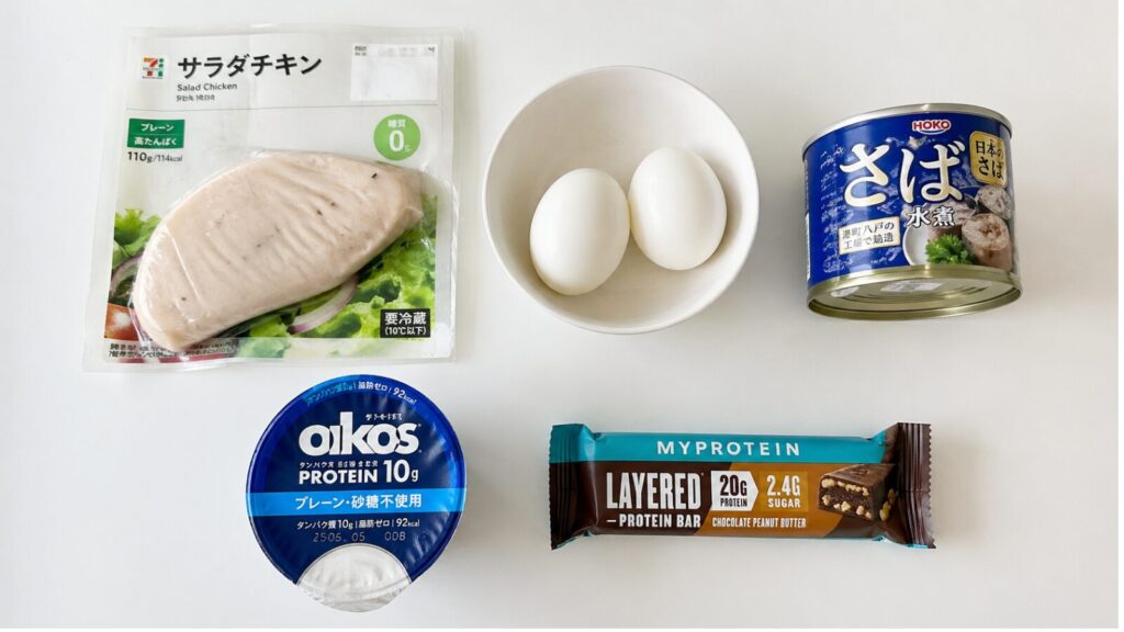サラダチキン・ゆで卵・サバ缶・ギリシャヨーグルト・プロテインバーを机に並べた写真
